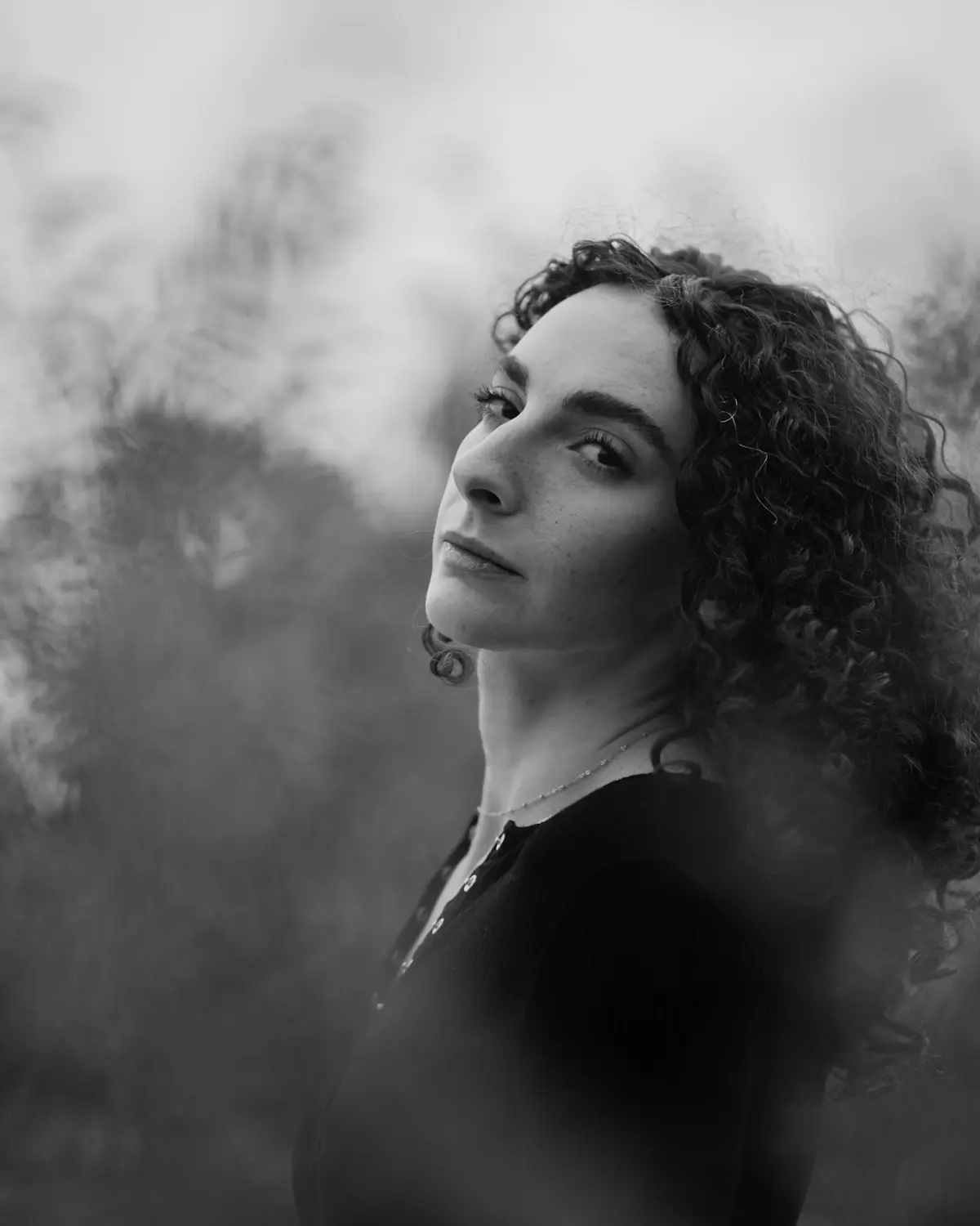 Retrato em preto e branco de mulher de cabelo cacheado
